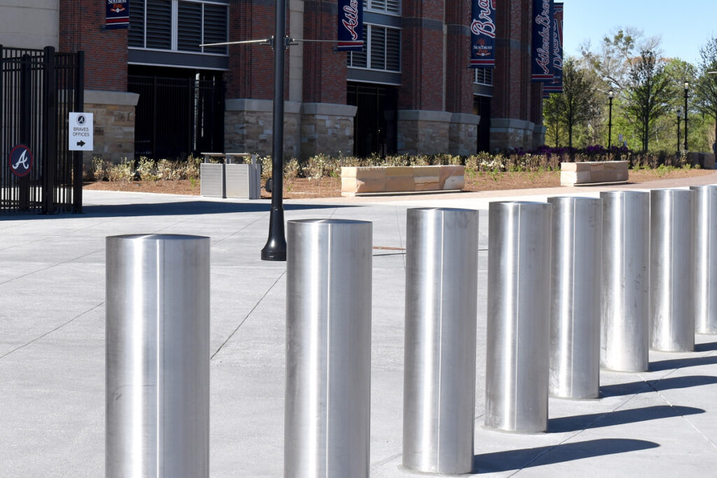 Stainless steel passive bollards arranged beside a walkway near a stadium serving as anti-vehicular, anti-ram security protection