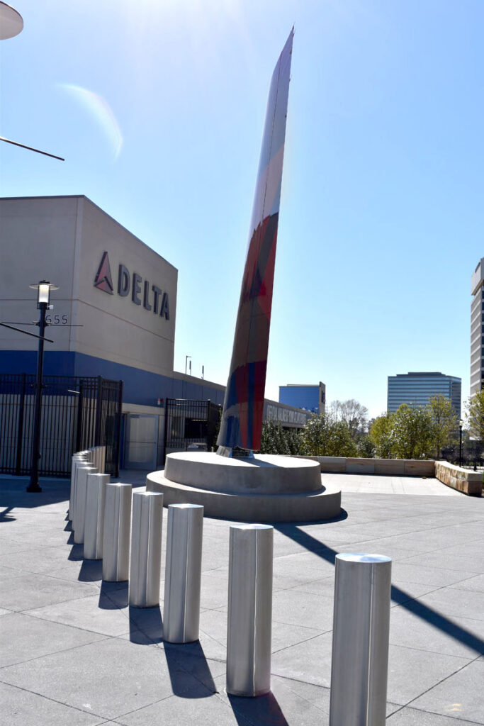 Modern steel bollards securing a pedestrian plaza near a Delta corporate facility.